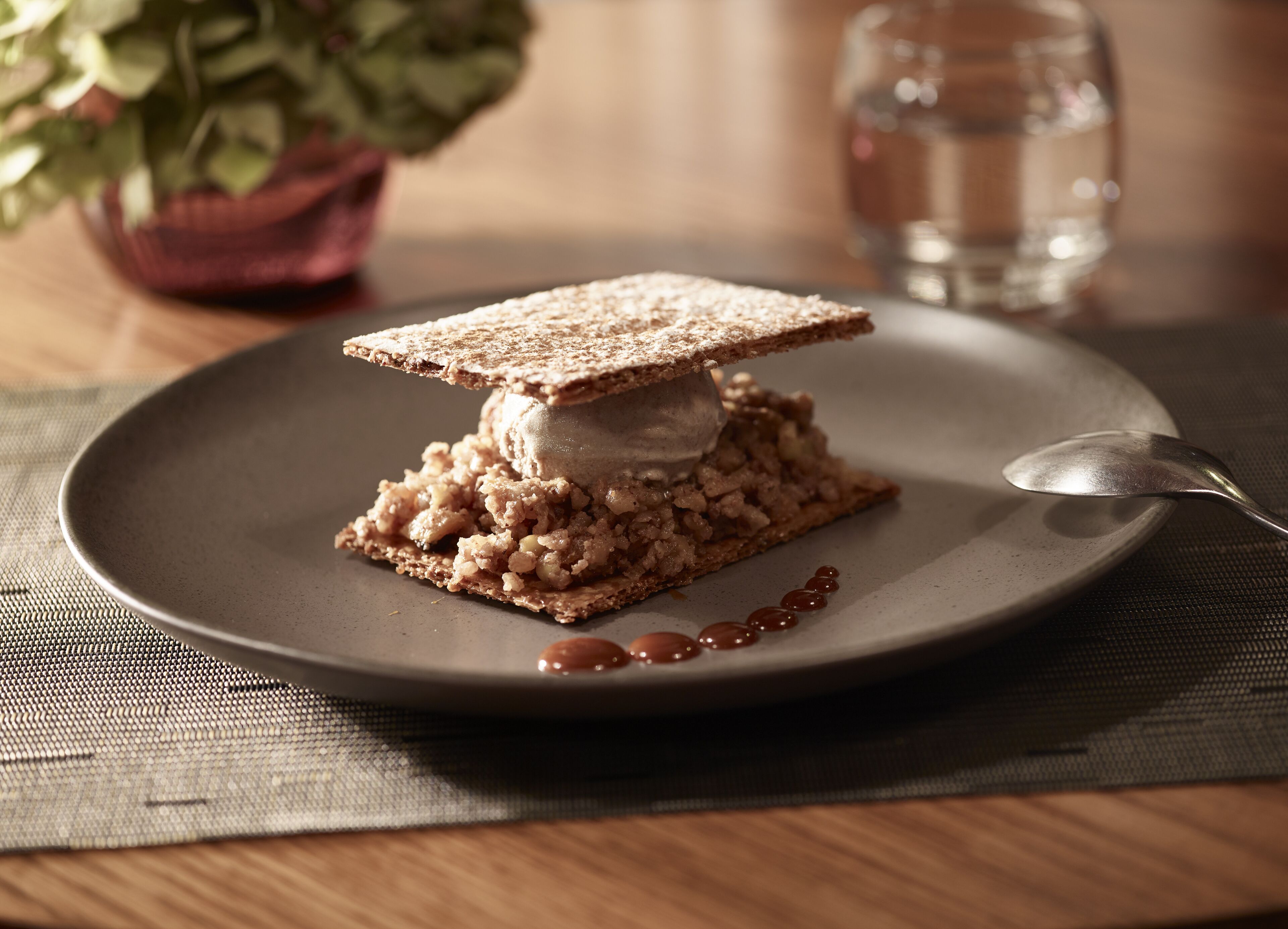 A dessert on a plate with a spoon beside it.