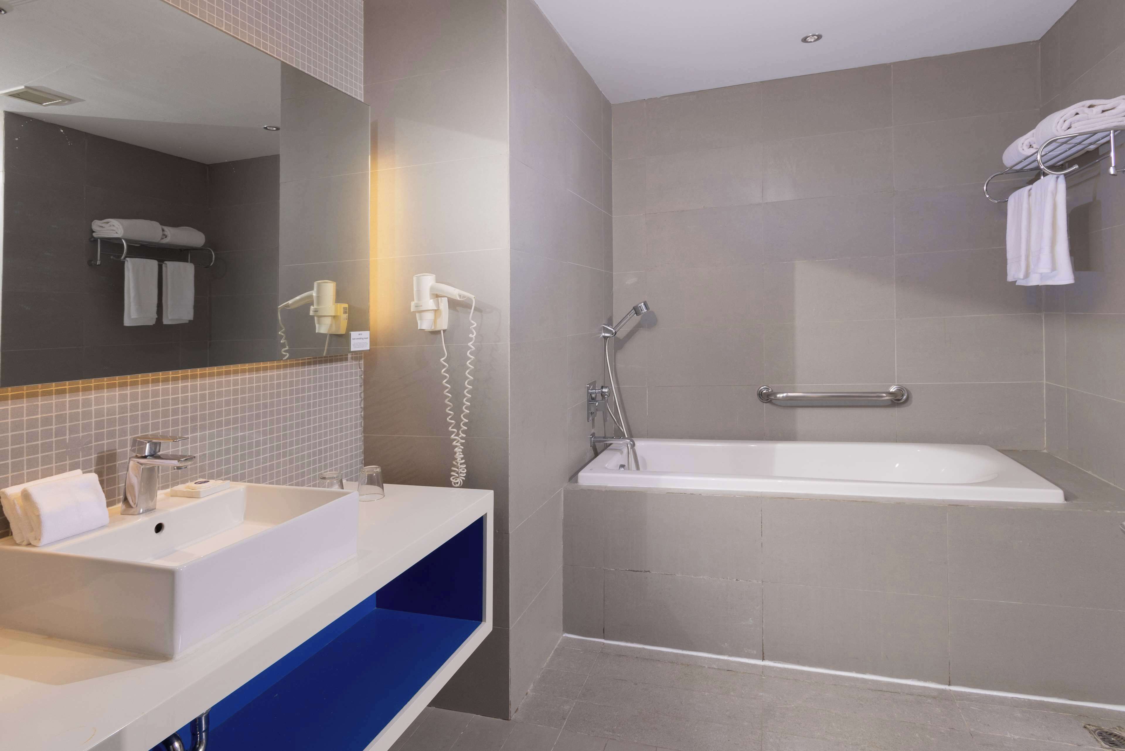 junior suite, 1 king bed, accessible bathtub, city view | bathroom | eco-friendly toiletries, hair dryer, bidet, towels