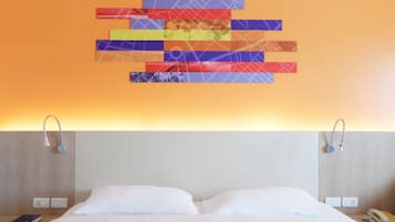 Una habitación de hotel con una cama, dos mesitas de noche, una lámpara de pared y una obra de arte en la pared.