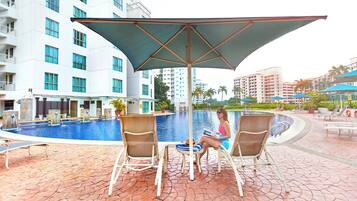 Una piscina al aire libre, tumbonas