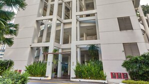A modern high-rise building with multiple floors, large windows, and a curved architectural design.