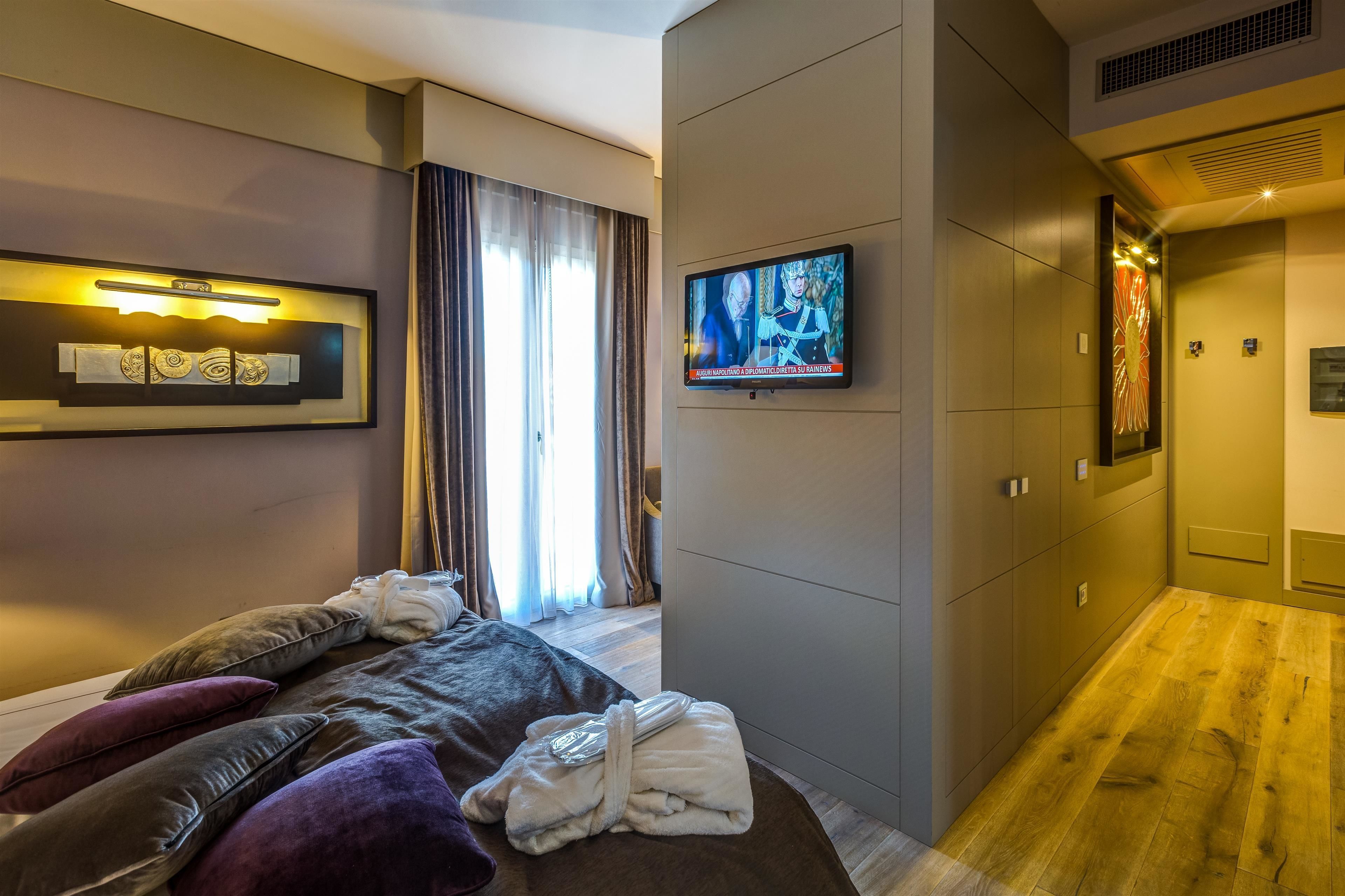 Una habitación de hotel moderna con cama, televisor y armario.