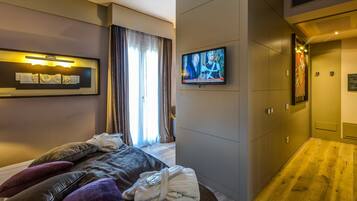 Una moderna camera d'albergo con un letto, una televisione e un armadio.