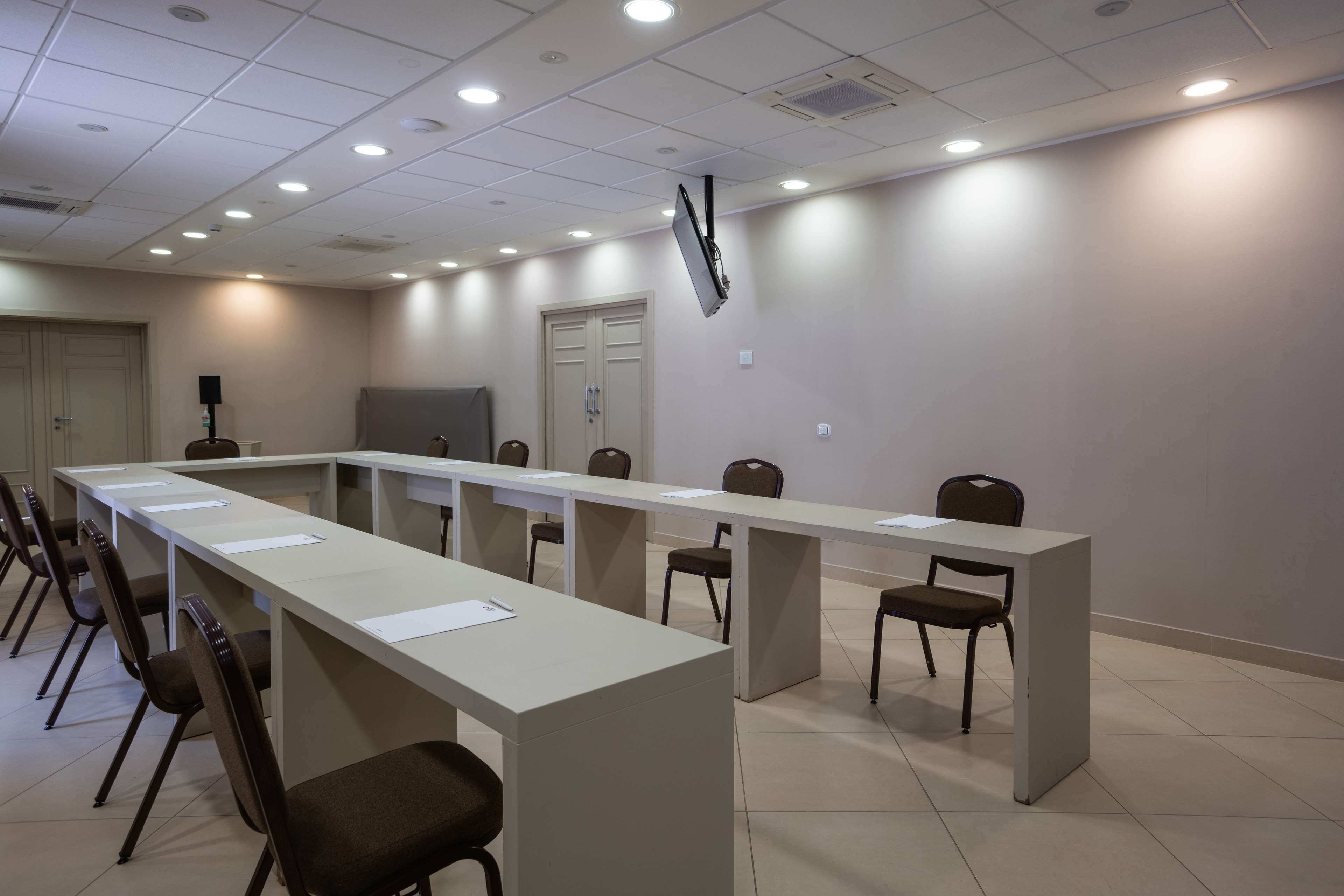 Une salle de conférence équipée d’une longue table, de chaises et d’un écran de projection.