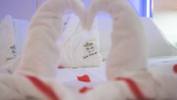 Una cama con toallas blancas y una decoración con forma de corazón.
