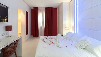 Una camera d'albergo con un letto, una scrivania, una sedia e una finestra con tende.