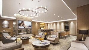 Amplia sala de estar con chimenea, asientos cómodos, una zona de bar y una gran pantalla de televisión.