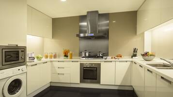 A modern kitchen with a built-in microwave, oven, and stainless steel range hood.
