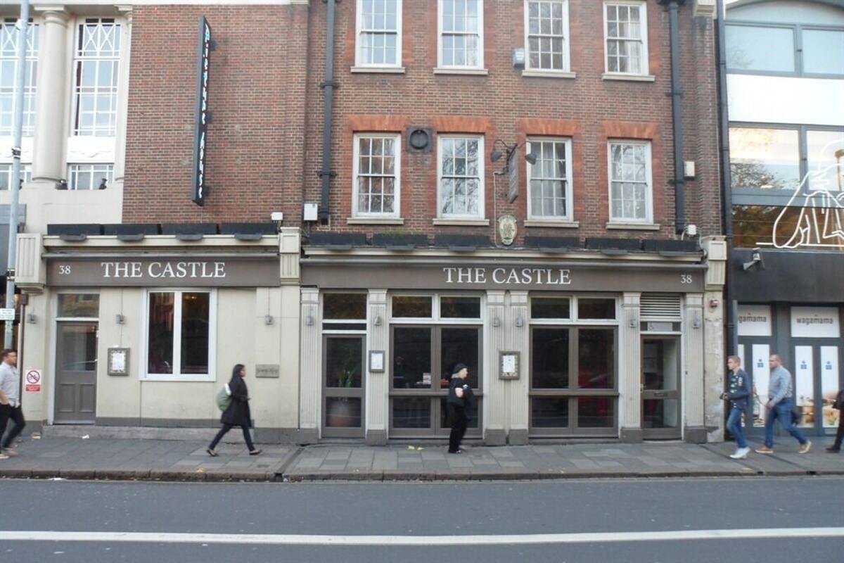 Un edificio con un letrero que dice "The Castle" a nivel de la calle.