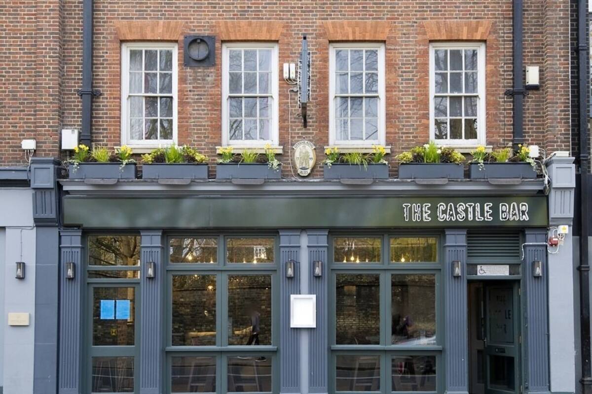 Un edificio de ladrillo con un letrero que dice "The Castle Bar".