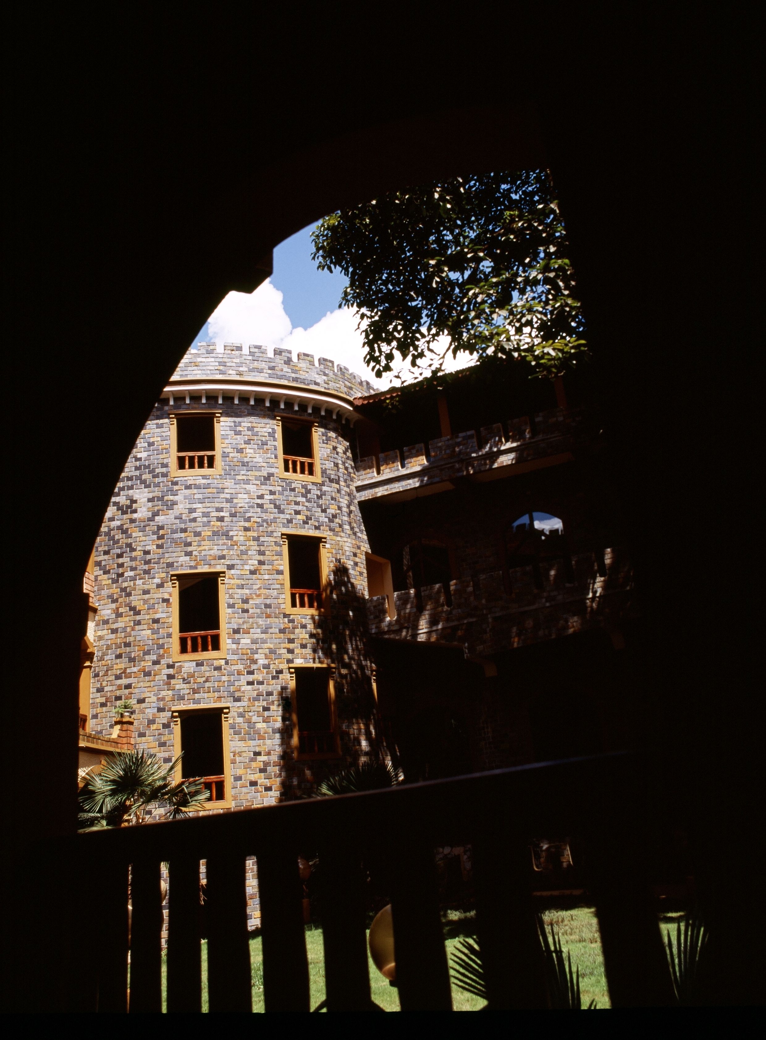 Un bâtiment en pierre doté de nombreuses fenêtres et d’un balcon.