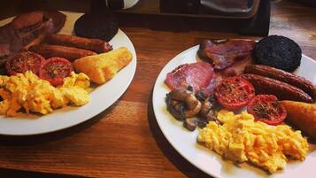 Two plates of breakfast food on a wooden table.