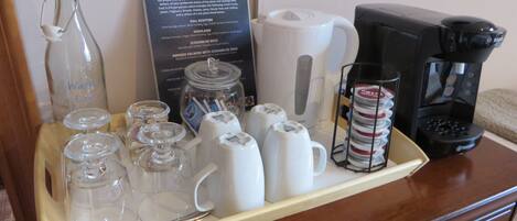 A breakfast tray with various items including a coffee maker, cups, and a menu.