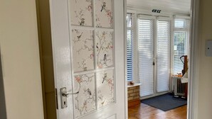 A white door with a floral pattern, leading to a room with wooden flooring and a radiator. - Fourwinds Leisure (March)