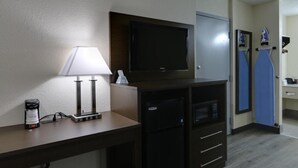 A hotel room with a desk, a television, a coffee maker, a microwave, and a mini-fridge. - Baymont by Wyndham Ridgeland I-95 (Ridgeland)