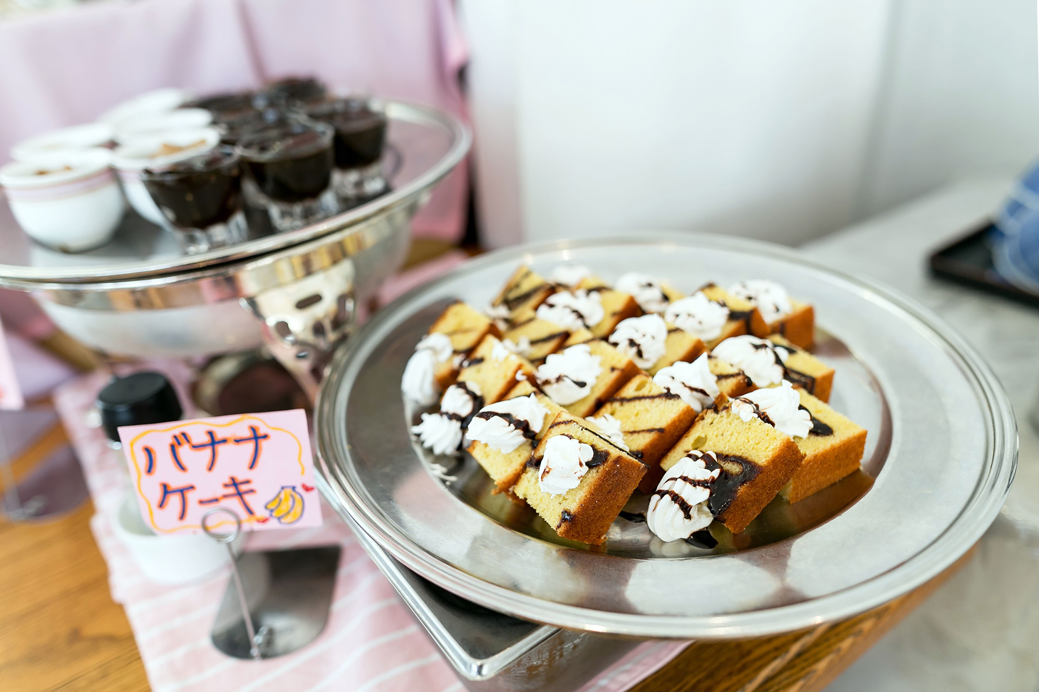 A dessert display with various cakes and pastries on trays.