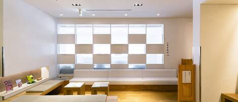 Un interior moderno con una zona de estar, suelo de madera y un ventanal con diseño de cuadrícula.