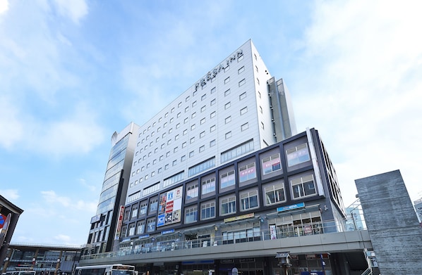 Ein modernes Hotel mit mehreren Etagen, großen Fenstern und verschiedenen Hinweisschildern.