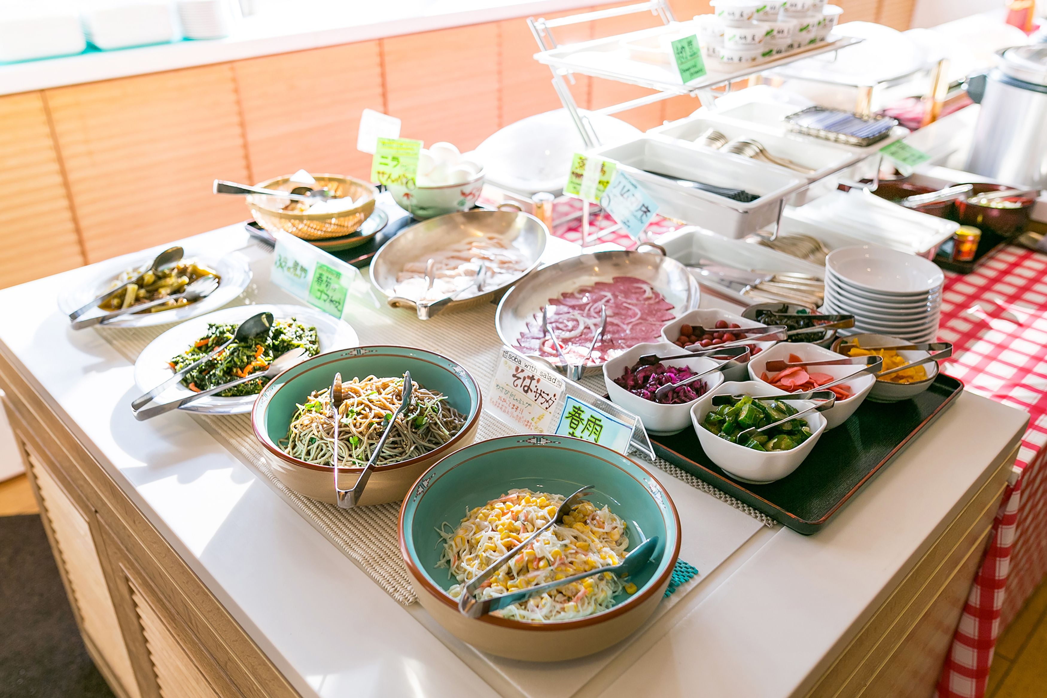 A buffet table with various dishes and utensils.