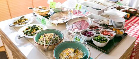 A buffet table with various dishes and utensils.