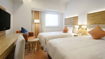 A hotel room with two beds, a desk, a chair, a television, and a window with curtains.