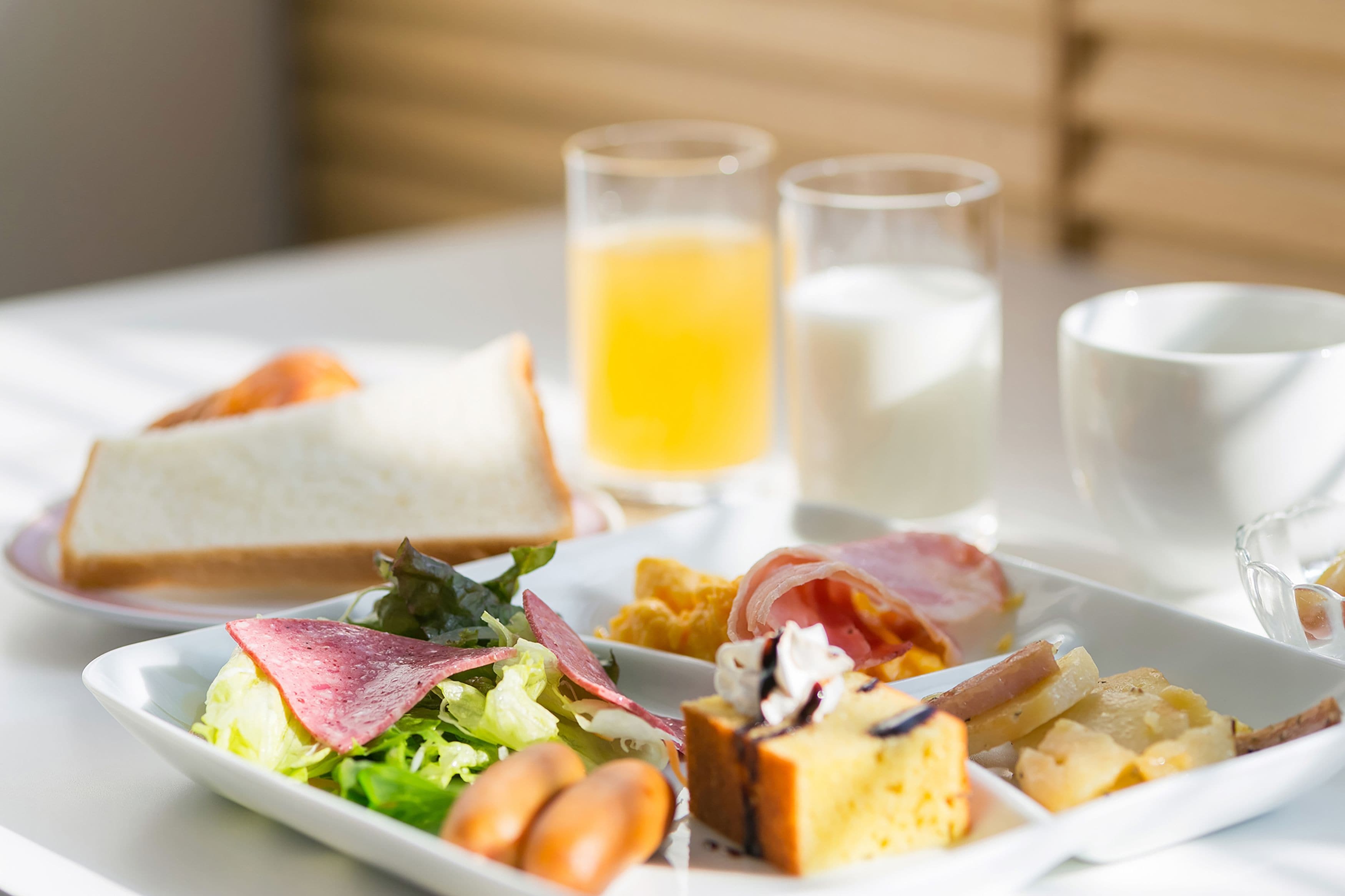 A breakfast plate with toast, eggs, ham, and a side salad.