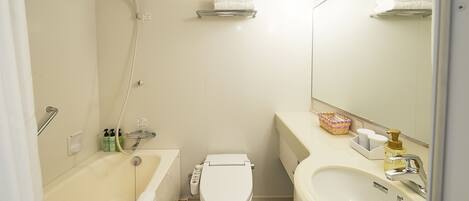 A bathroom with a bathtub, toilet, sink, and a mirror.