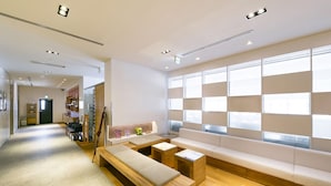 A modern waiting area with a long bench, a small table, and a sofa.