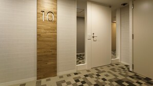 A hallway with a wooden accent wall, a number '10' sign, and a checkered floor pattern.
