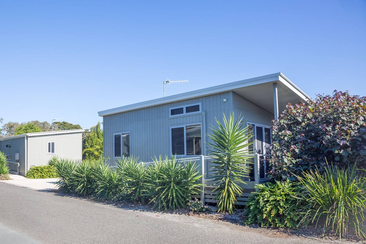 A two-story building with a flat roof and a satellite dish.