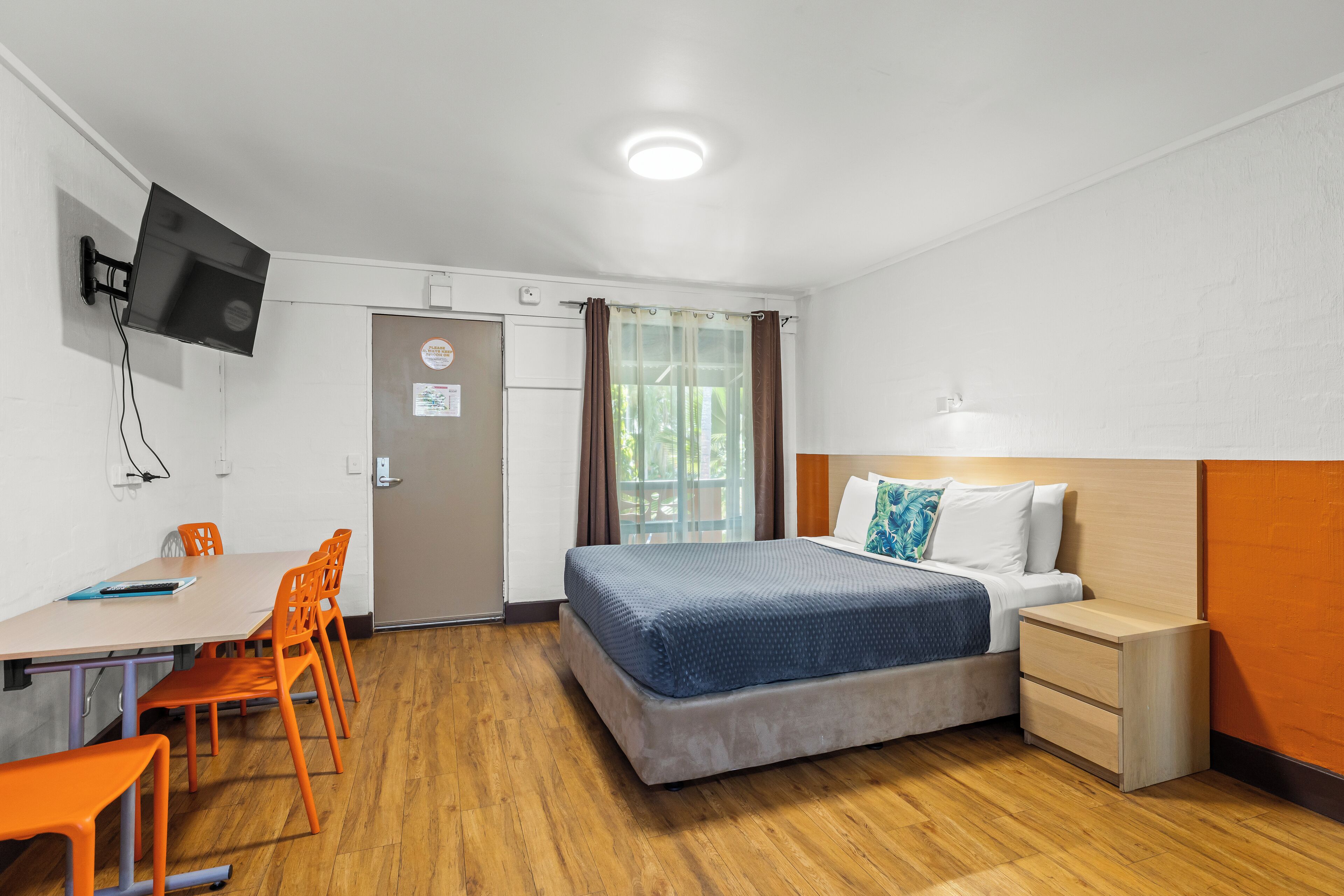 Une chambre à coucher comprenant un lit, une table de chevet et un bureau avec des chaises.