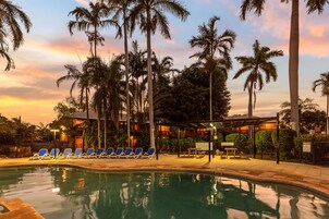 Una piscina al aire libre, sillones reclinables de piscina