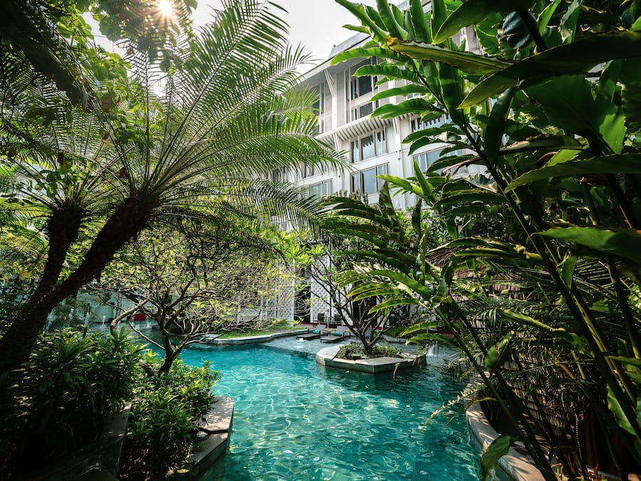 Una piscina al aire libre, sillones reclinables de piscina