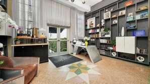 Um espaço de escritório moderno com escrivaninha, cadeira, estante e vista para o exterior.
