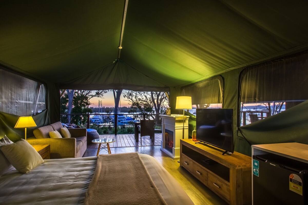 Ein gemütliches Interieur mit einer Couch, einem Fernseher und einem Tisch mit Blick auf eine Marina.