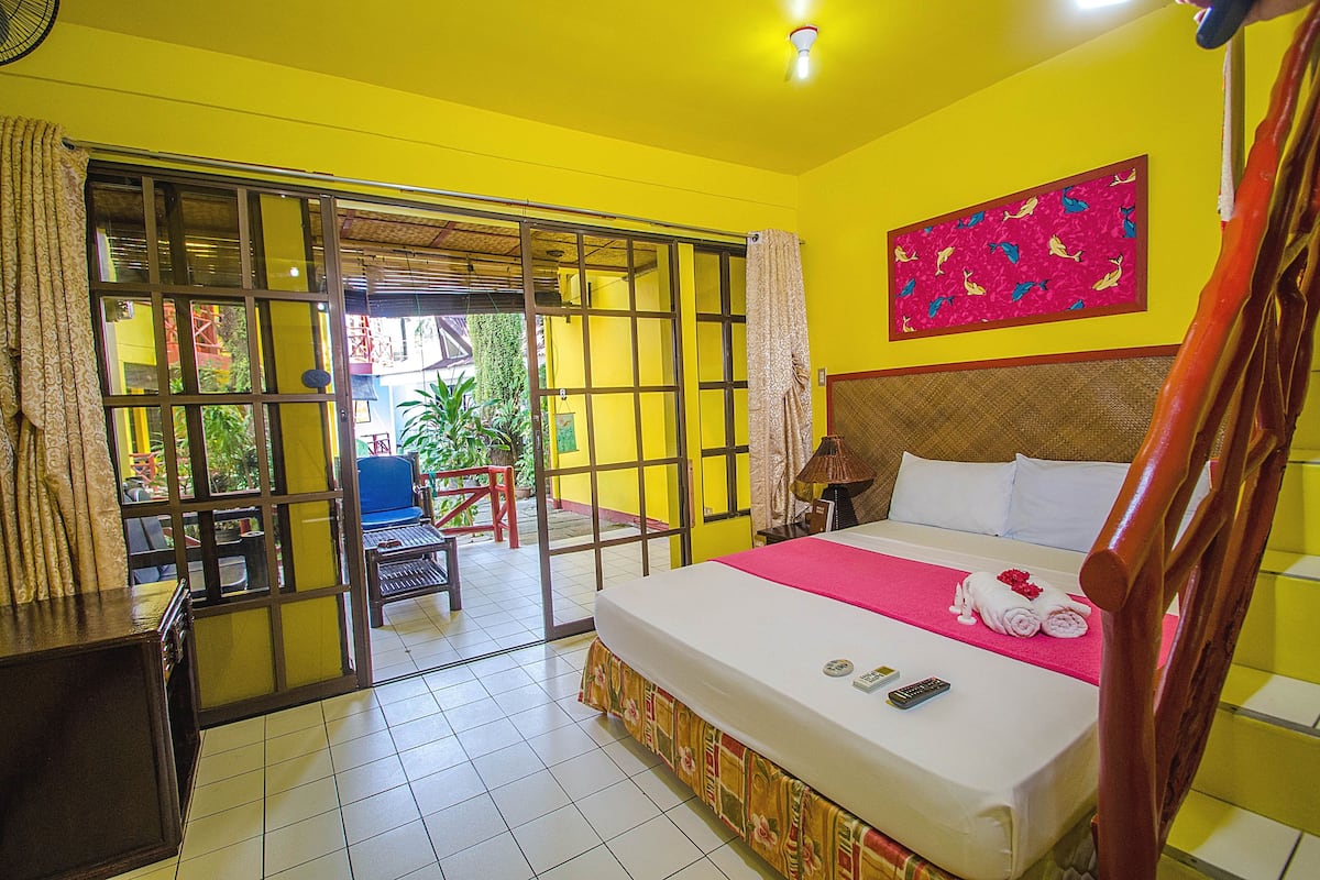 Ein Hotelzimmer mit Bett, Schreibtisch und Blick ins Freie.