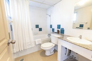 A bathroom with a bathtub, toilet, sink, and a shower.