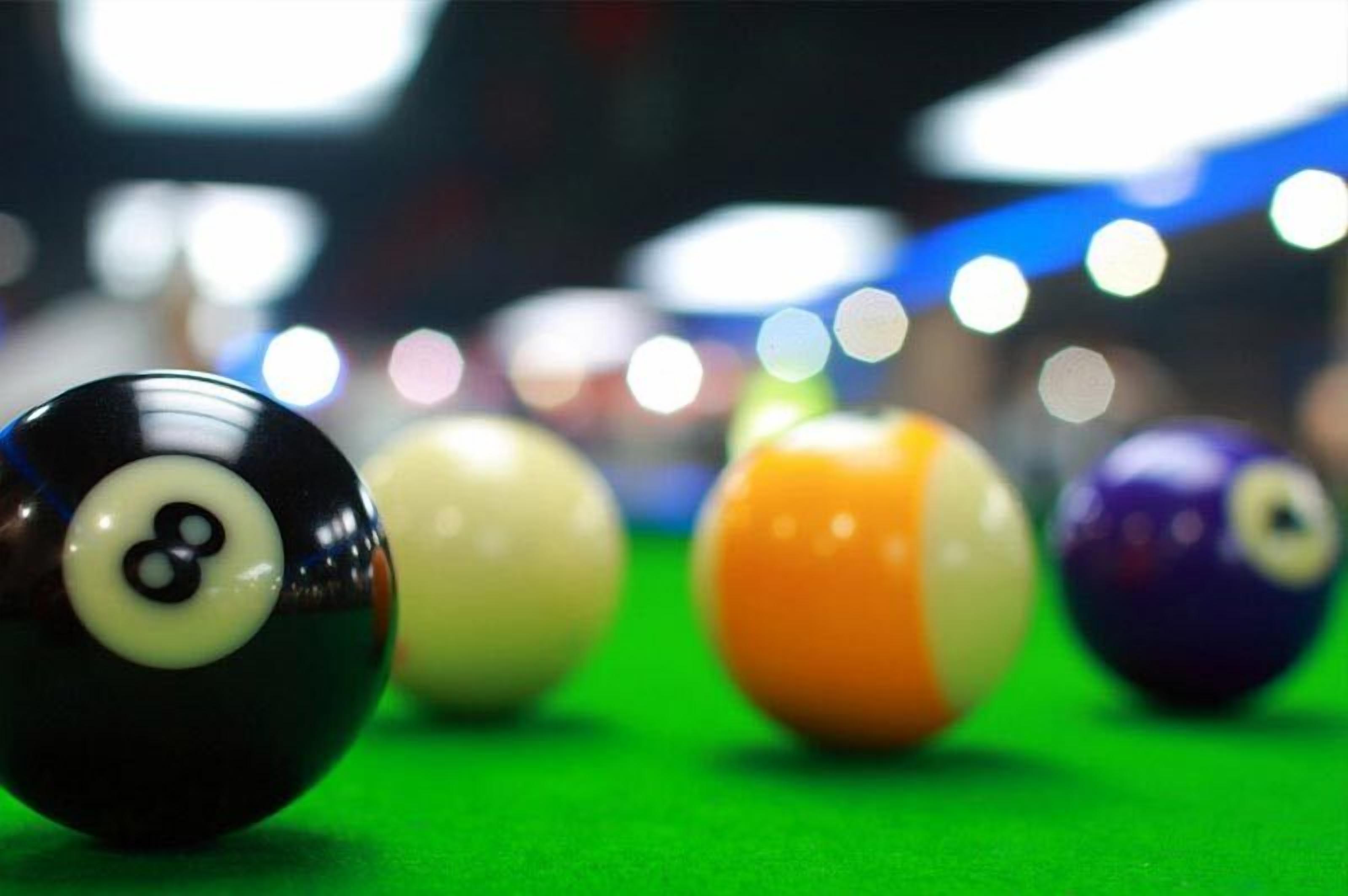 A close-up of billiard balls on a green felt surface.