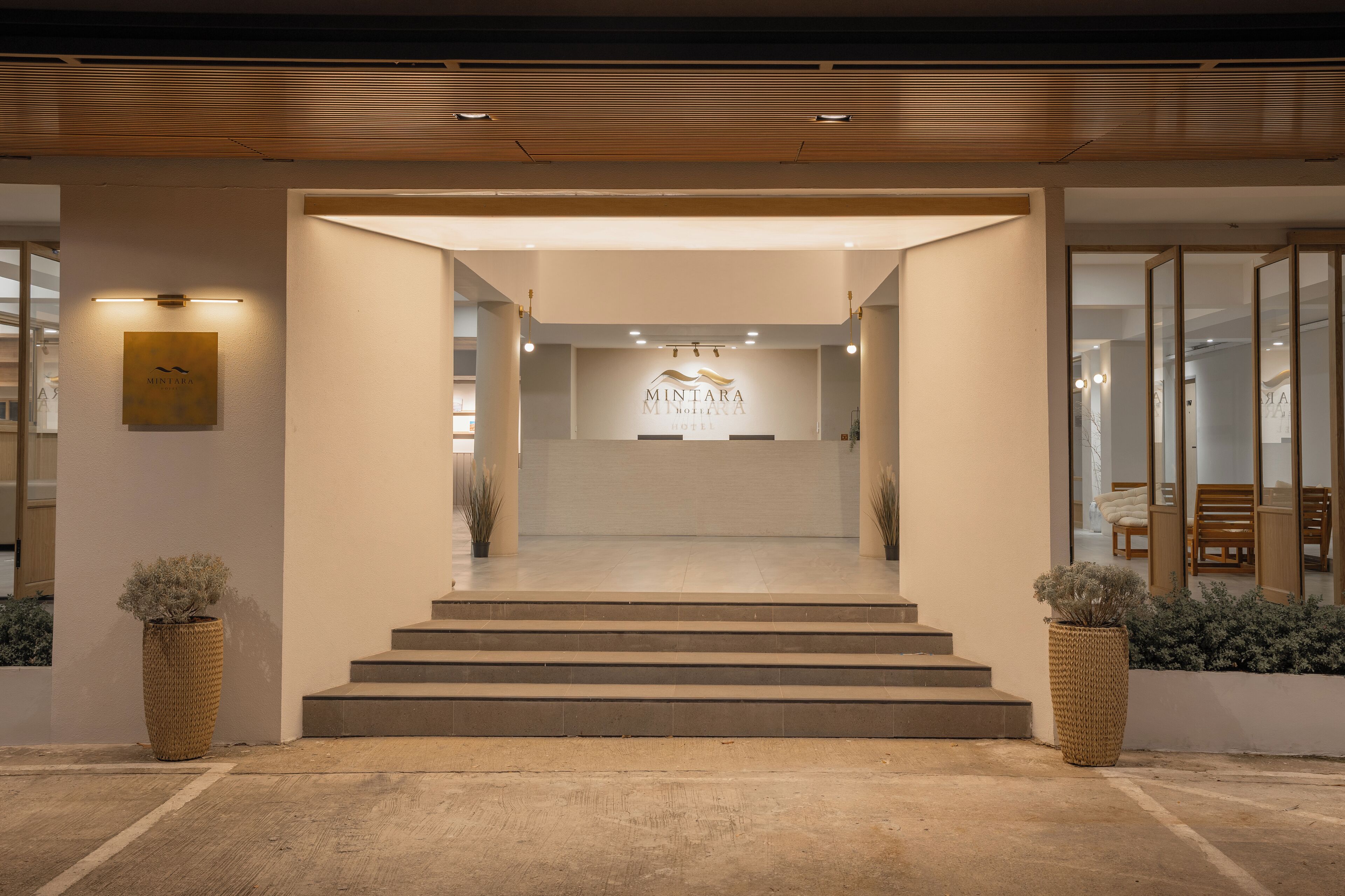 A modern hotel entrance with a sign reading "MINTARA Hotel."