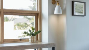 A modern kitchen with a wooden countertop, a white pendant light, and a framed picture on the wall. - Mintara Hotel (Bangkok)