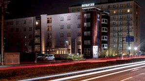 Un hôtel à plusieurs étages, doté d’une façade moderne, d’une enseigne lumineuse et d’une entrée bien visible.