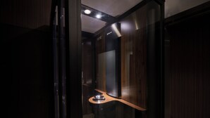 Une salle de bain moderne avec un meuble-lavabo en bois, un miroir et un spot encastré au plafond.