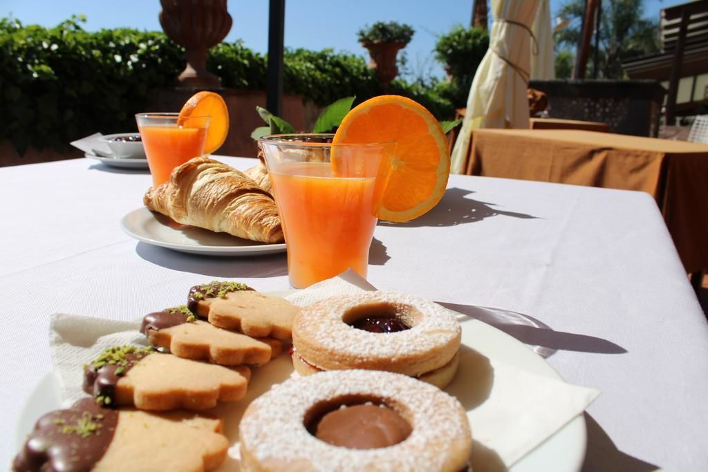 A table with a croissant, orange juice, and various pastries.
