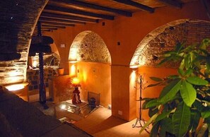 A dimly lit interior with stone arches, a staircase, and a plant in the foreground. - Il Ciliegio dell'Etna (Giarre)