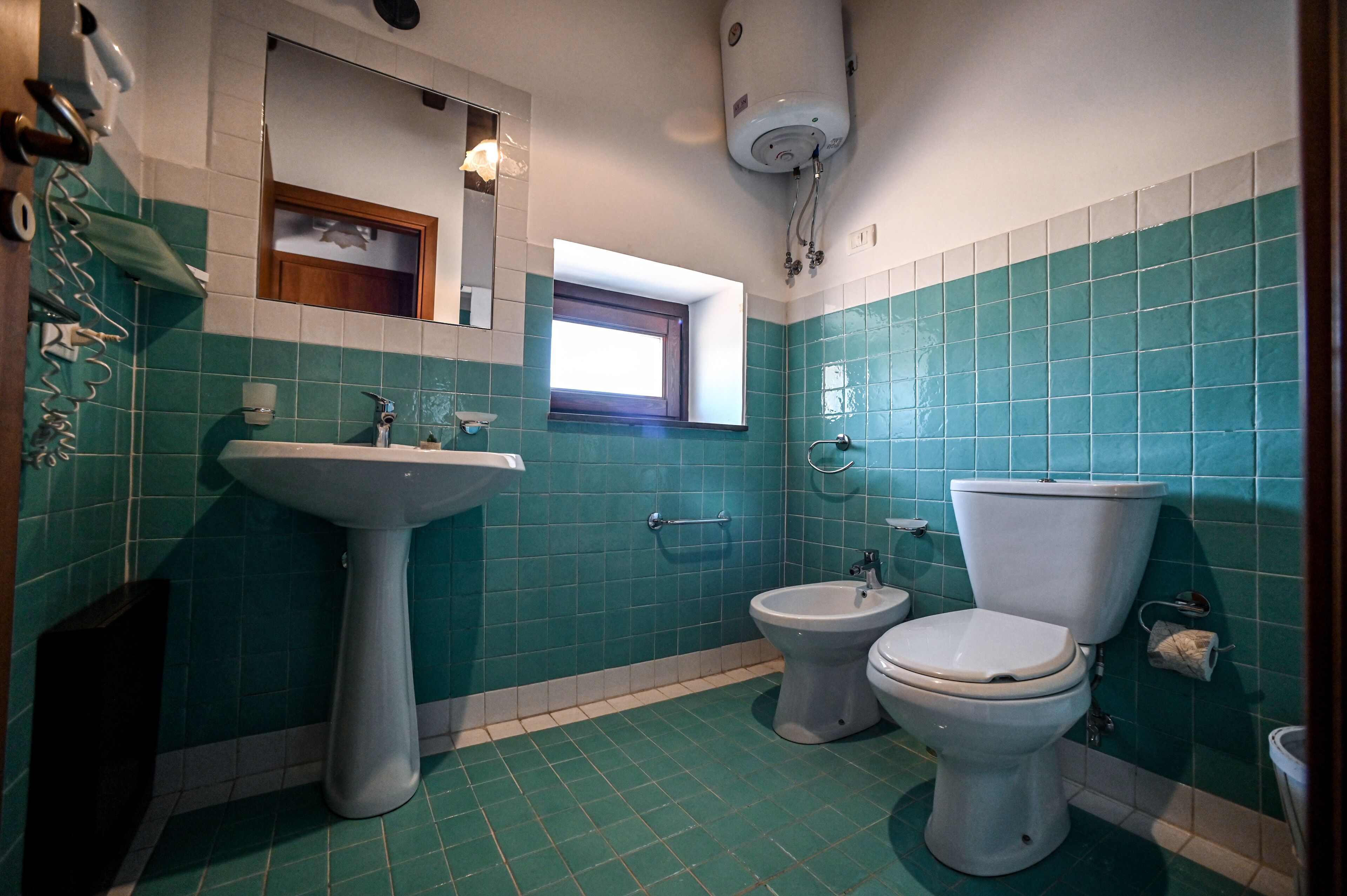 A bathroom with a pedestal sink, a bidet, and a toilet.