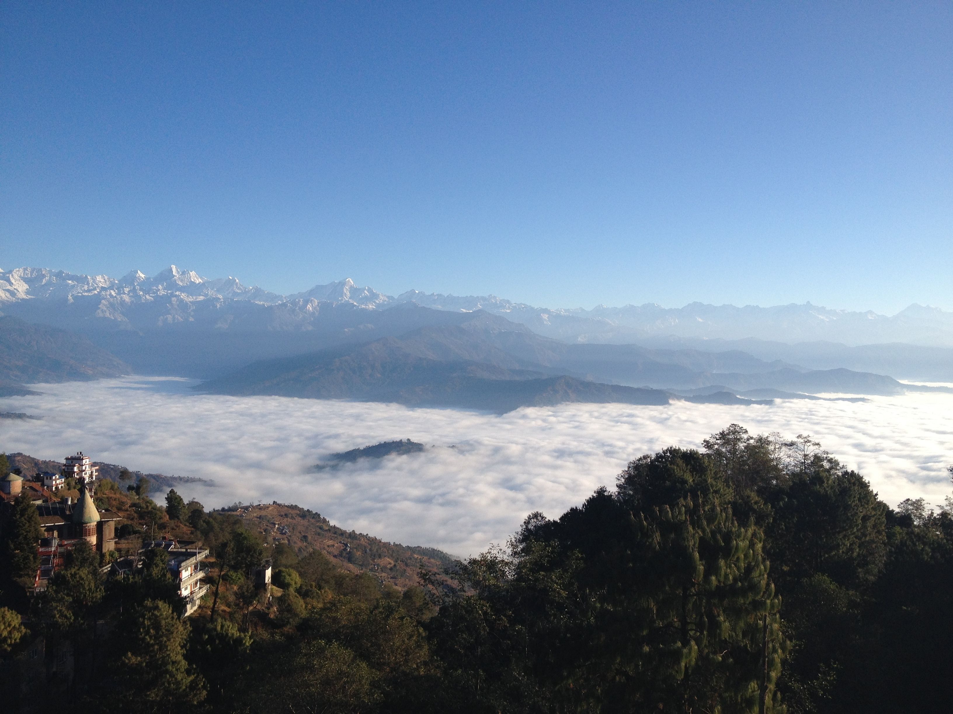 A mountainous landscape with a village nestled among trees.