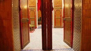 An ornate hallway with intricate tile work and a central column. - Riad La Maison Verte (Fes)