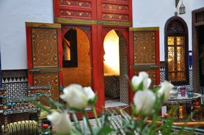 Un patio interior con puertas ornamentales y un diseño tradicional marroquí.