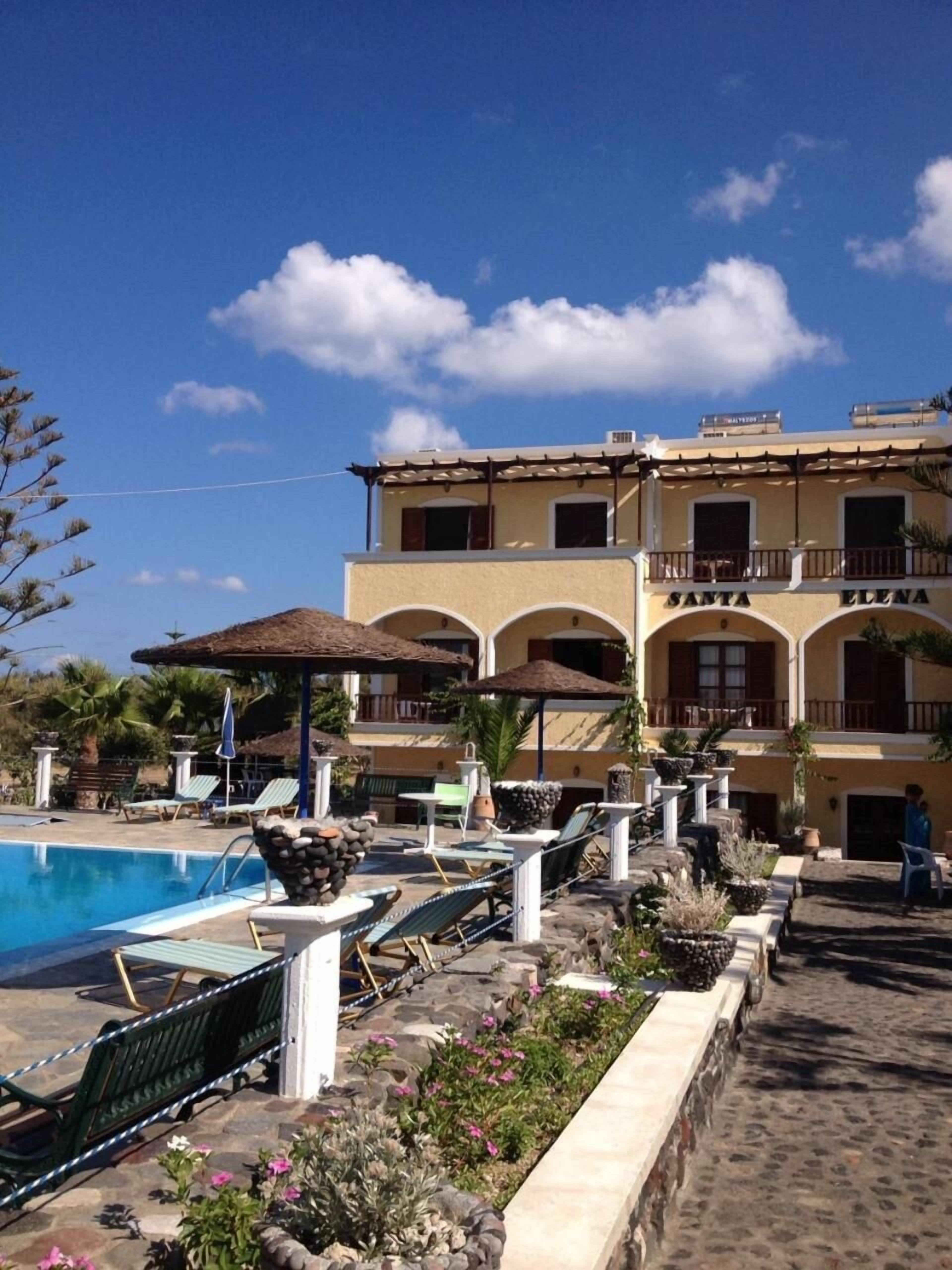 Um resort com piscina, espreguiçadeiras e um edifício com varandas.