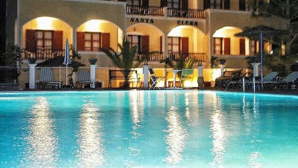 Un hotel con piscina, varios balcones y zonas de estar al aire libre.